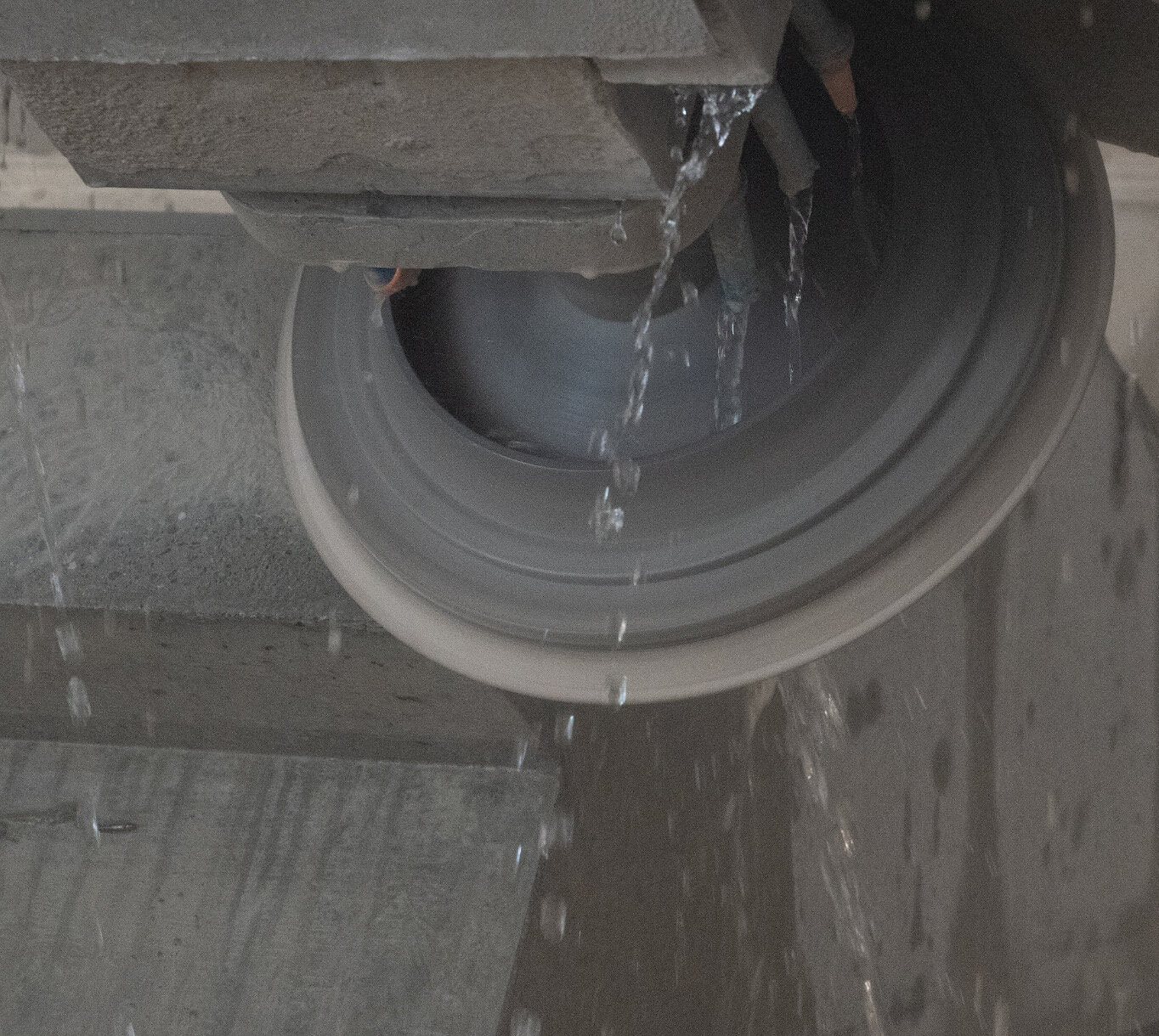 Wasser läuft aus einem Rohr in eine Betonrinne