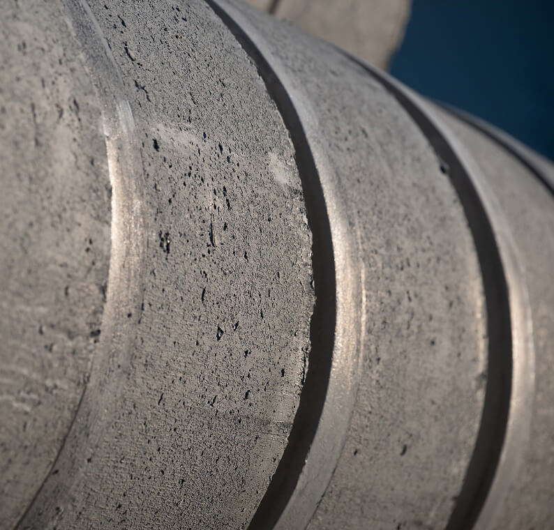 Nahaufnahme einer grauen Betonoberfläche mit runden, vertieften Rillen