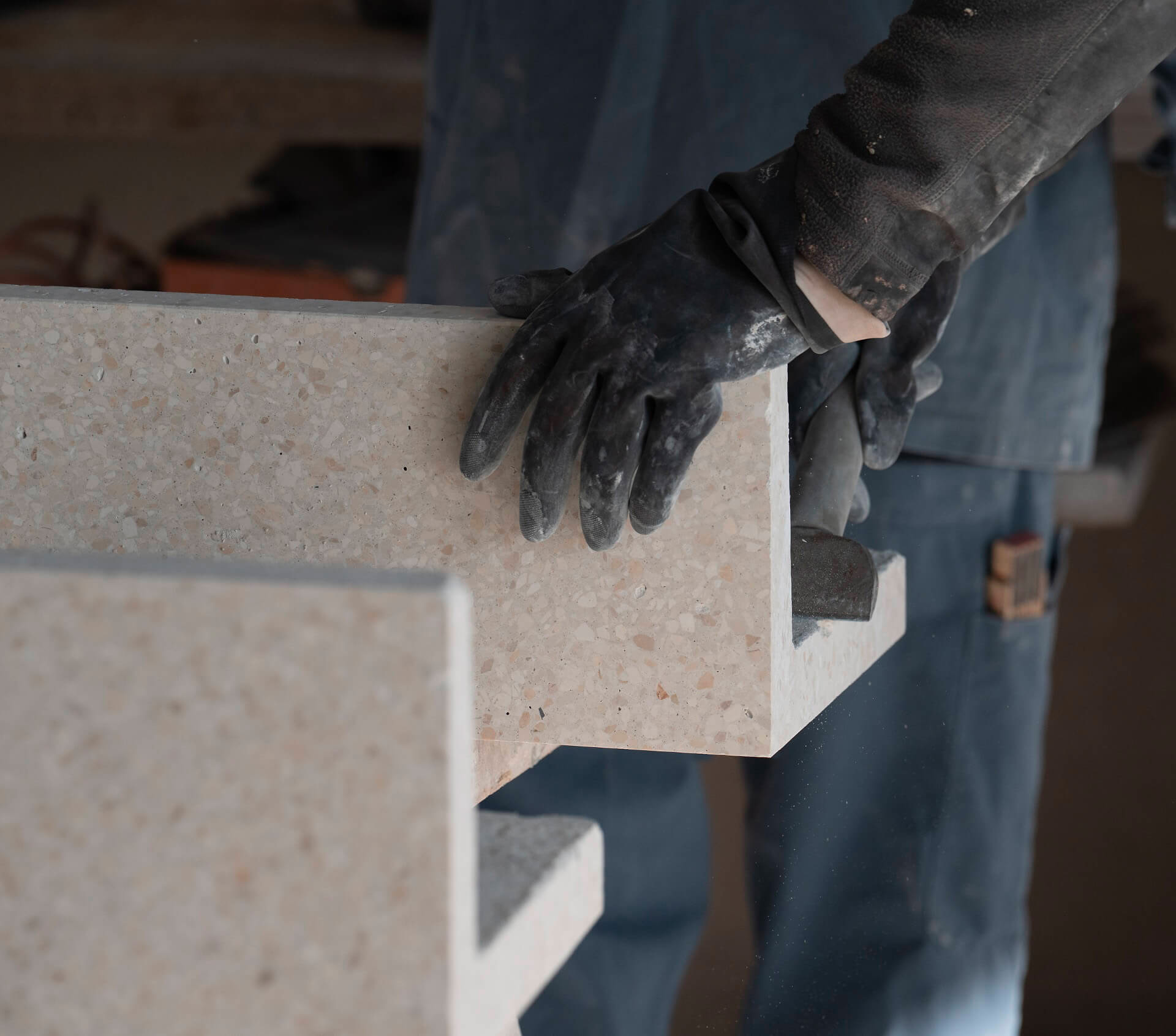 Arbeiter mit Handschuhen positioniert eine Steinplatte