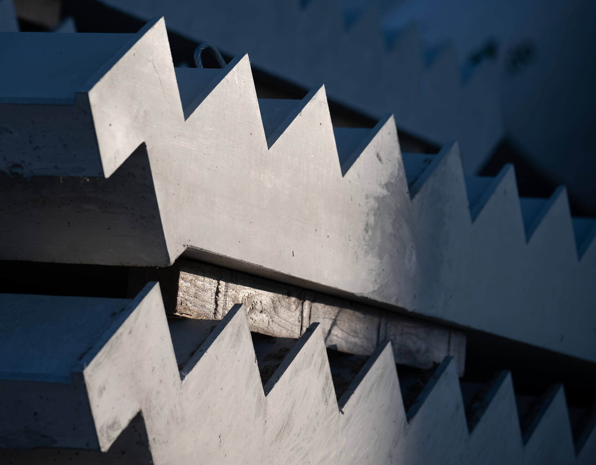 Nahaufnahme einer weißen, gezackten Metallkante mit Schatten und abgenutzter Oberfläche