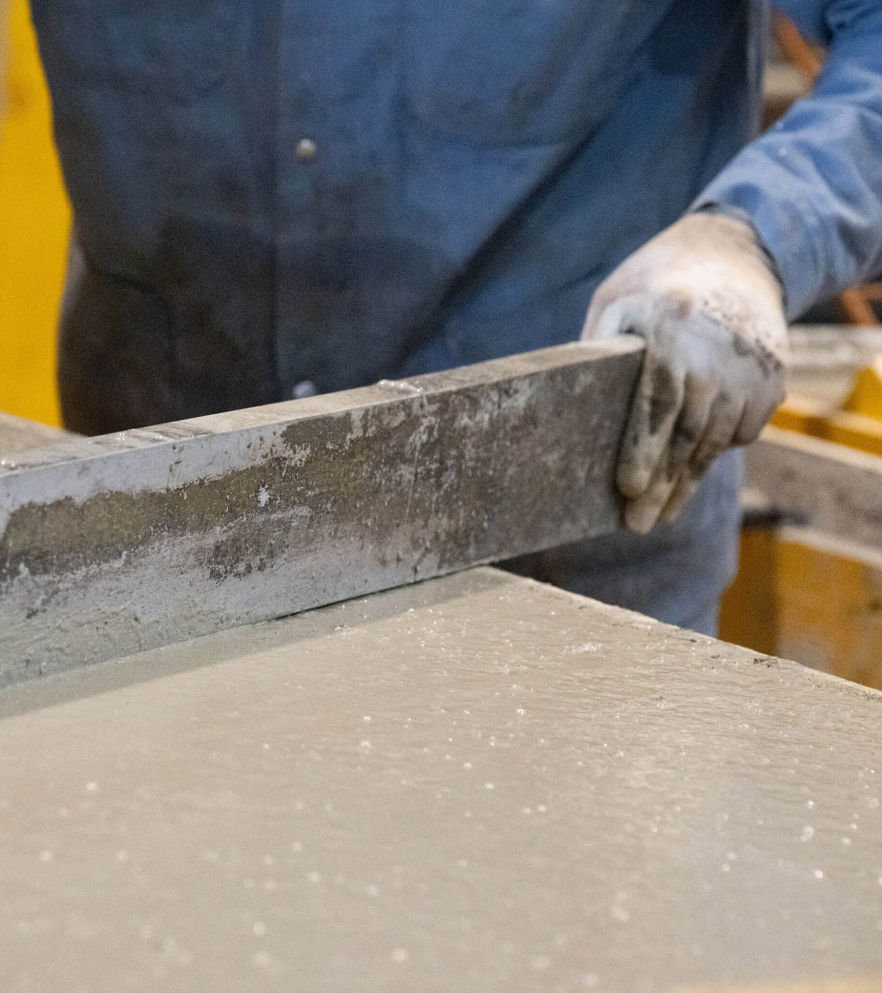 Arbeiter hält eine schwere Metallplatte in einer Werkstatt