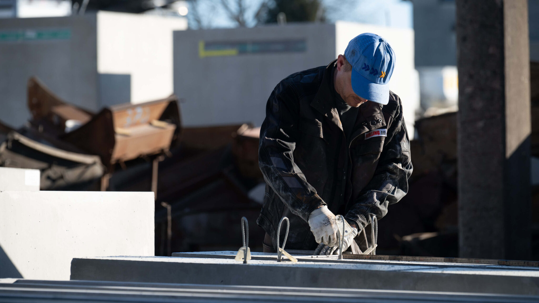 Bauarbeiter mit blauer Kappe arbeitet auf einer Baustelle an einer Betonkonstruktion