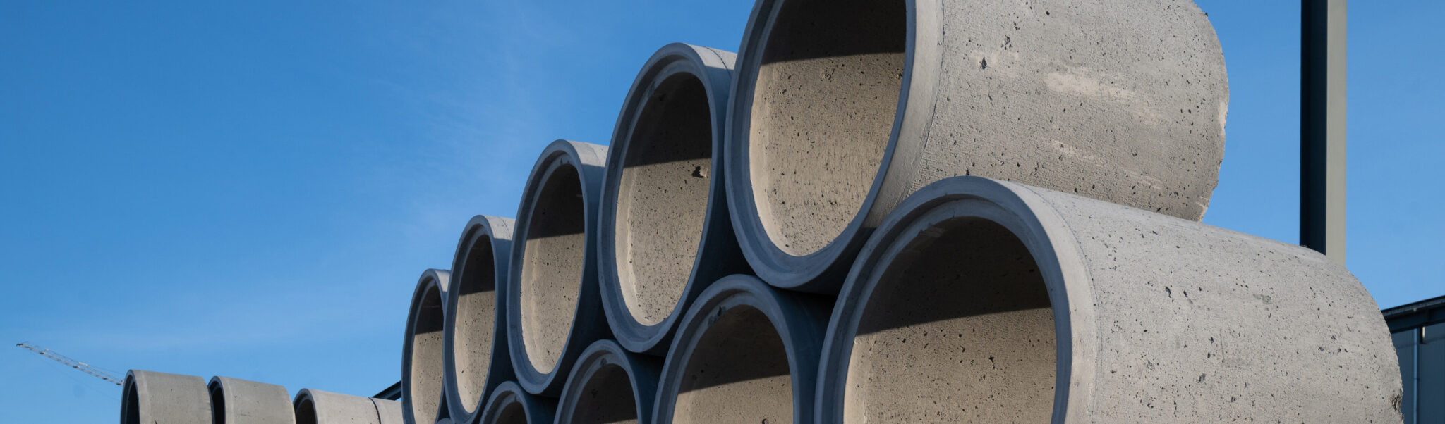 Gestapelte Betonrohre vor blauem Himmel