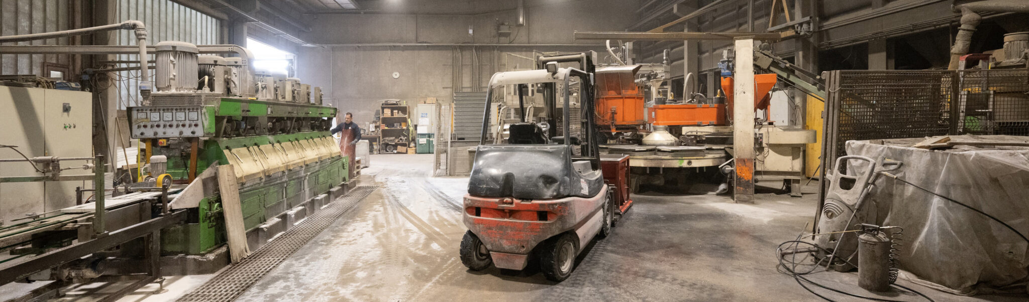 Industriehalle mit Maschinen und einem Gabelstapler in der Mitte